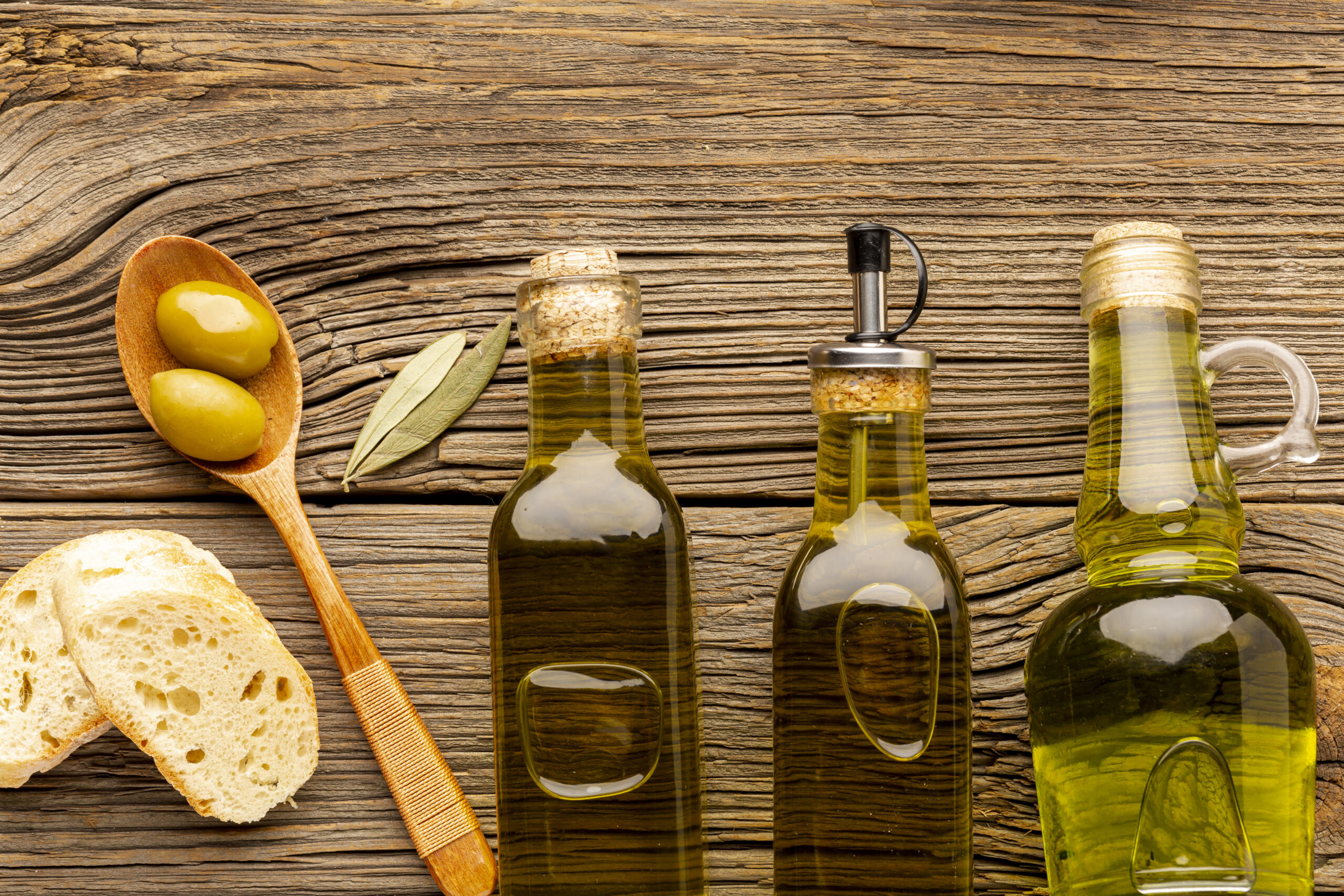 flat lay oil bottles bread wooden spoon